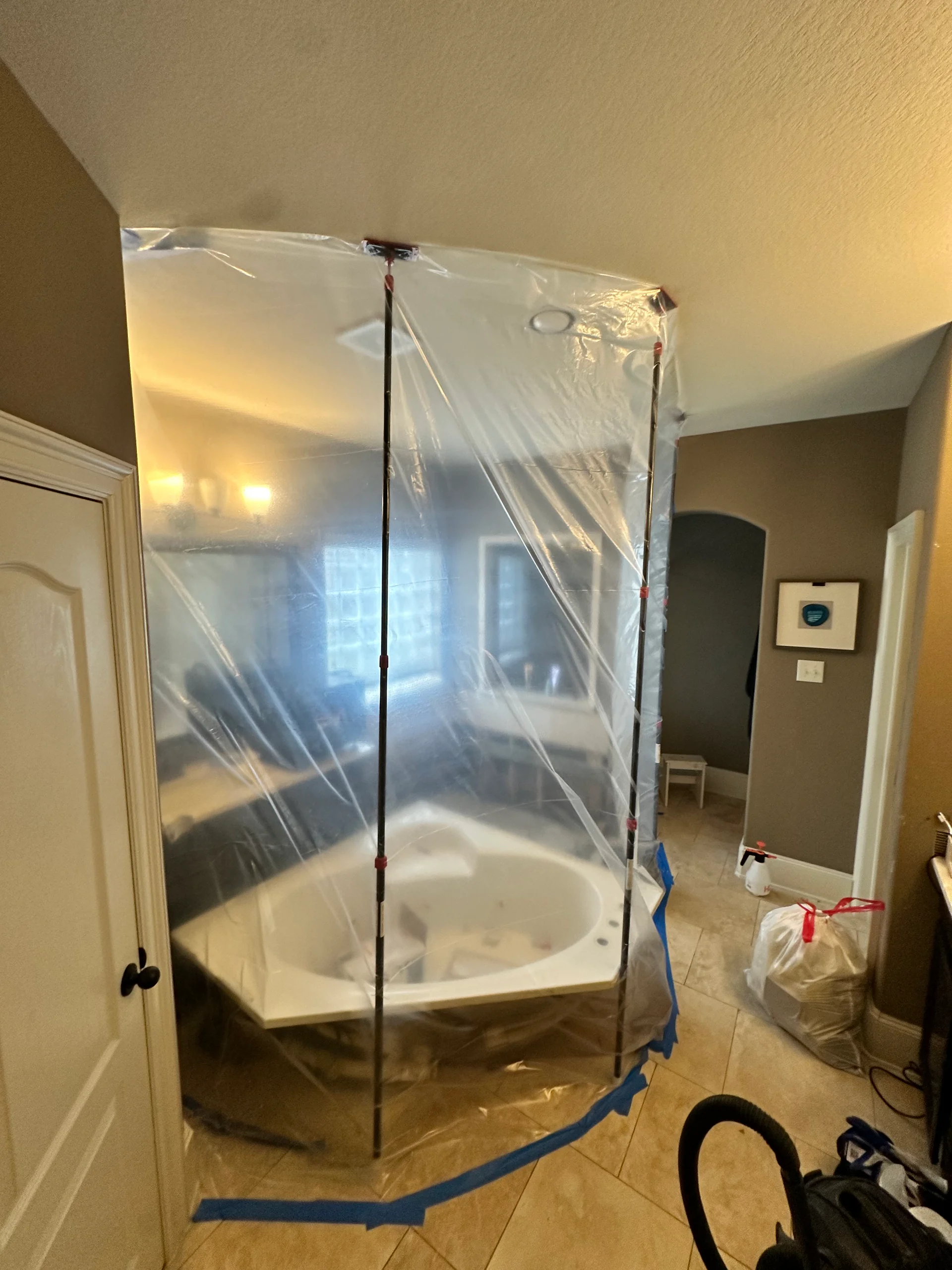 Bathroom containment with plastic sheeting taped to the floor by Bayou City during a mold remediation job
