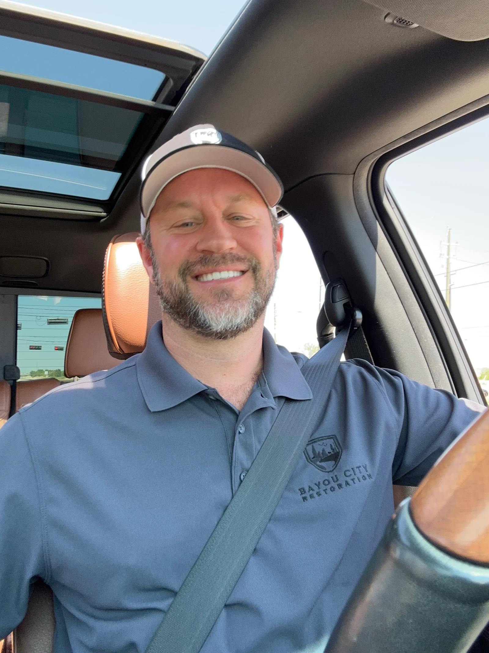 Bayou City Water Restoration owner Neil Walker smiling from his service truck in a branded BCWR polo, ready for a Katy or west Houston dispatch